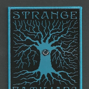 May include: Black and blue embroidered patch with a tree and the text "STRANGE FAMILIARS".