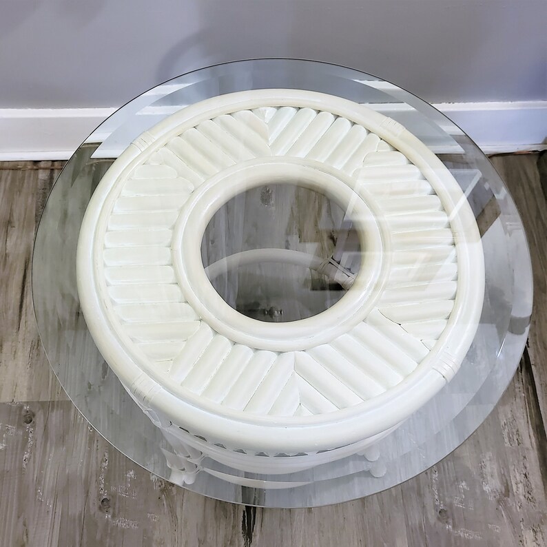May include: White wicker end table with a round glass top. The table has a woven design and a circular opening in the center.