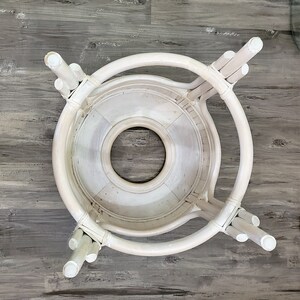 May include: White wicker table base with a round top and a center hole. The base has a woven design and is made of natural materials.