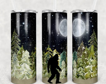 Peut inclure: Un gobelet en acier inoxydable avec un motif noir et blanc d'un Bigfoot marchant dans une forêt la nuit. Le motif présente une pleine lune et des étoiles dans le ciel. Le gobelet a un fond aquarelle vert et marron.