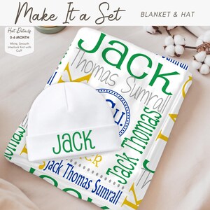 A white baby hat with the name "Jack" printed on it, placed on top of a blanket with the name "Thomas Sumrall" printed on it.
