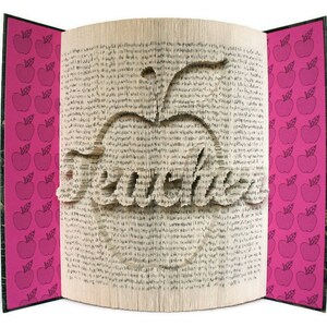 May include: A book with pages folded into the shape of an apple with the word "Teacher" inside. The cover of the book is pink with a pattern of red apples.