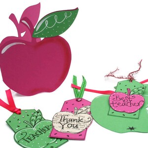 May include: Three green apple-shaped gift tags with pink accents. The tags have different messages: "Teacher", "Thank You", and "Best Teacher".