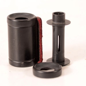 以下が含まれることがあります： 赤いフェルトの裏地が付いた黒いプラスチック製のフィルムケース、黒いプラスチック製のフィルムスプール、黒いプラスチック製のフィルム巻き取りスプール