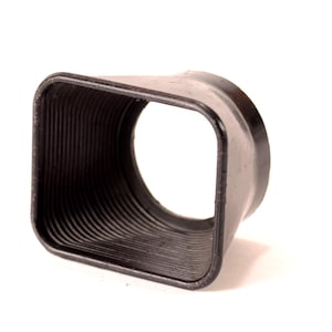 May include: A black rubber lens hood with a square shape and a ribbed design.