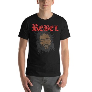 May include: Black t-shirt with a red "REBEL" graphic and a black and white image of a person with a crown of thorns.