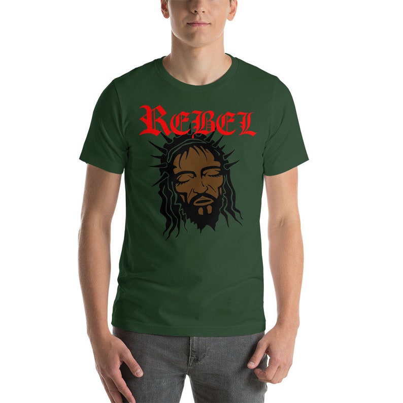 May include: A dark green t-shirt with a black and red graphic of a person's face with a crown of thorns and the word "REBEL" in red letters.