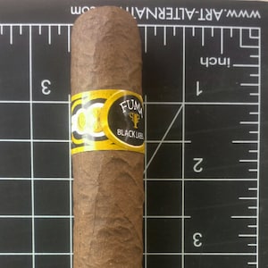 May include: A brown cigar with a gold and black band that says "FUMA BLACK LABEL".