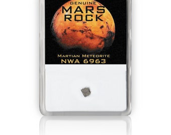May include: A small, gray Martian meteorite, labeled "NWA 6963", is displayed in a clear plastic case with a red and orange image of Mars. The case has a black label that reads "Genuine Mars Rock" and "Martian Meteorite".
