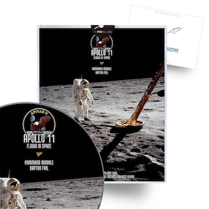 Può includere: Una fotografia in bianco e nero del modulo di comando dell'Apollo 11 sulla luna. Il modulo è ricoperto da uno scudo termico argentato. La foto è etichettata "Apollo 11 Flown in Space Command Module Kapton Foil" e "Luglio 1969 Neil Collins e Buzz Aldrin".