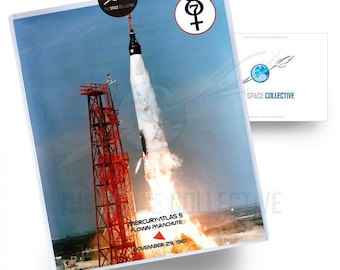 May include: A black and white photo of a rocket launching from a red launchpad. The rocket is labeled "Mercury-Atlas 5 Flown Parachute November 29, 1961".