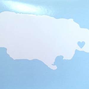 May include: A white outline of the island of Jamaica with a small blue heart in the center.