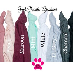 May include: A selection of t-shirts in various colors, including mauve, peach, maroon, mint, white, light grey, charcoal, and black. The t-shirts are folded and arranged in a row. Pink Poodle Creations is written at the top of the image.