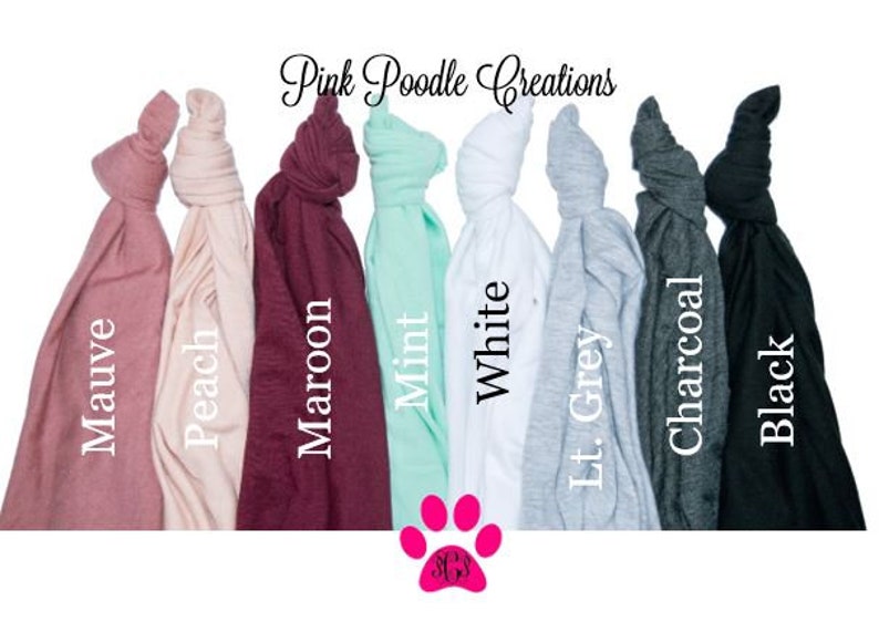 May include: A selection of t-shirts in various colors, including mauve, peach, maroon, mint, white, light grey, charcoal, and black. The t-shirts are folded and arranged in a row. Pink Poodle Creations is written at the top of the image.