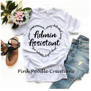 May include: A gray t-shirt with a black circle design that says "Admin Assistant" with the words "warm, compassionate, caring, dedicated, loving, fun, reliable, loyal, kind" surrounding the text.