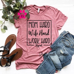 May include: A pink t-shirt with the text "Mom Hard Wife Hard Work Hard Repeat" in a black box.