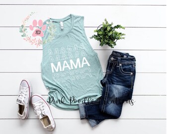 Può includere: Un top senza maniche di colore azzurro chiaro con la parola "MAMA" ripetuta in un design grafico bianco. Il top è appoggiato su una superficie di legno bianco con un paio di scarpe da ginnastica bianche, un paio di jeans blu e una pianta in vaso.