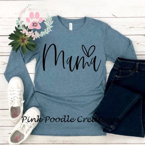 May include: A teal blue long-sleeved shirt with the word "Mama" in black script with a small heart above the "a".