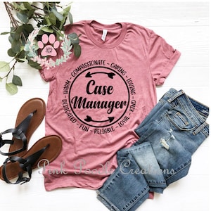 May include: A pink t-shirt with a black circle design that says "Case Manager" with arrows and words around the circle. The words are "Warm - Compassionate - Caring - Loving - Kind - Dedicated - Fun - Reliable - Loyal".