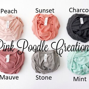 May include: Six folded t-shirts in different colors: peach, sunset, charcoal, mauve, stone, and mint. The shirts are labeled with the color names and the text "Pink Poodle Creations".
