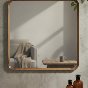 May include: Square mirror with a wooden frame. The mirror reflects a room with a sofa, table, and bottles. The frame has rounded corners. The mirror is hanging on a concrete wall.