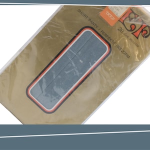 May include: A gold and white package with the text "SHORT PANTY / PERFEKTE PASVORM 20 den mousse" and a blue and white illustration of a pair of pantyhose.