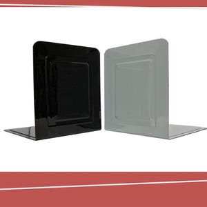 Pode incluir: Dois porta-livros, um preto e outro cinza, com um design simples e retangular. Eles são feitos de metal e têm uma ligeira curva na parte inferior.