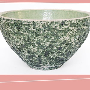 Op de afbeelding: Een grote, groene en witte keramische kom met een getextureerd oppervlak. De kom is rond en heeft een brede opening.