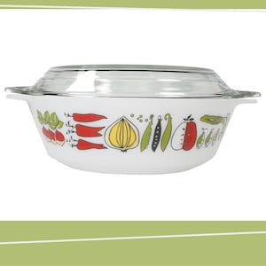 May include: White casserole dish with a clear glass lid. The dish features a colourful vegetable design, including red peppers, onions, and green beans. The dish has two handles and a silver rim. A vintage kitchenware item.