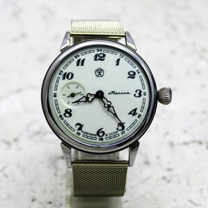 Könnte beinhalten: Eine silberne Armbanduhr mit weißem Zifferblatt und schwarzen Ziffern. Die Uhr hat ein geflochtenes Metallband und trägt die Aufschrift "Сделано в СССР" und "Молния" auf dem Zifferblatt.