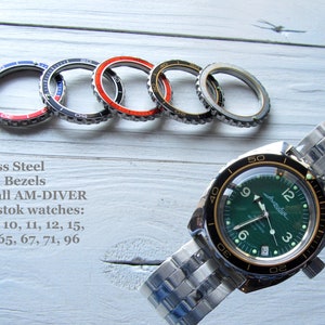 Pode incluir: Bezeis de relógio de aço inoxidável em várias cores, incluindo vermelho, preto e azul. Os bezeis são projetados para se ajustar aos relógios AM-DIVER e Vostok. O texto "Stainless Steel Custom Bezels" e "Fits to all AM-DIVER and Vostok watches: 06, 09, 10, 11, 12, 15, 35, 42, 65, 67, 71, 96" é visível na imagem.