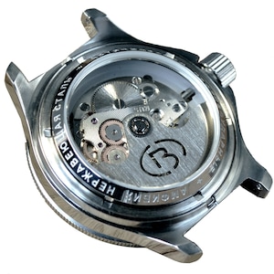 May include: A silver watch with a clear case back revealing the inner workings of the automatic movement. The watch face has the text "АВТОМАТИЧЕСКИЕ" and "НЕРЖАВЕЮЩАЯ СТАЛЬ" printed around the edge.