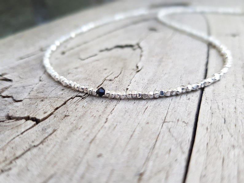 collana elegante e sottile, perfetta per uomo o donna, composta da pepite in argento solido ed al centro un piccolo cristallo in tre colori a scelta tra nero, verde smeraldo e blu zaffiro.
