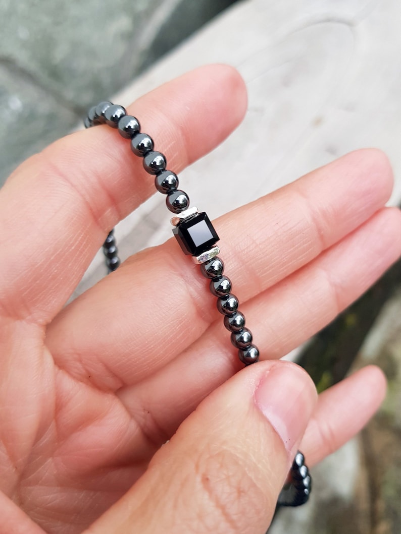 May include: A black hematite beaded bracelet with a square black onyx charm.