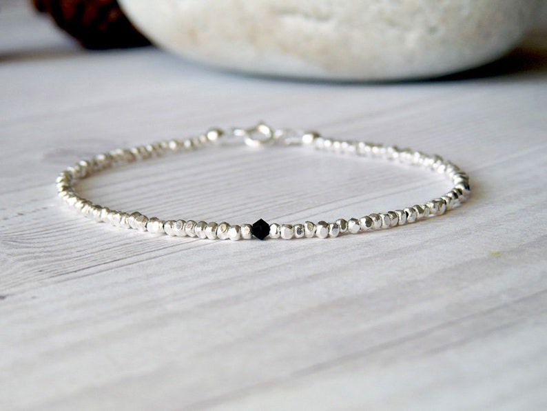 collana elegante e sottile, perfetta per uomo o donna, composta da pepite in argento solido ed al centro un piccolo cristallo in tre colori a scelta tra nero, verde smeraldo e blu zaffiro.