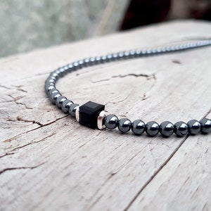 May include: A black hematite beaded necklace with a square black onyx pendant.