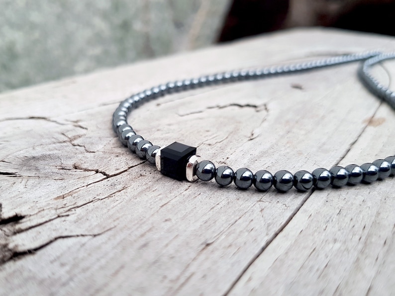 May include: A black hematite beaded necklace with a square black onyx pendant.