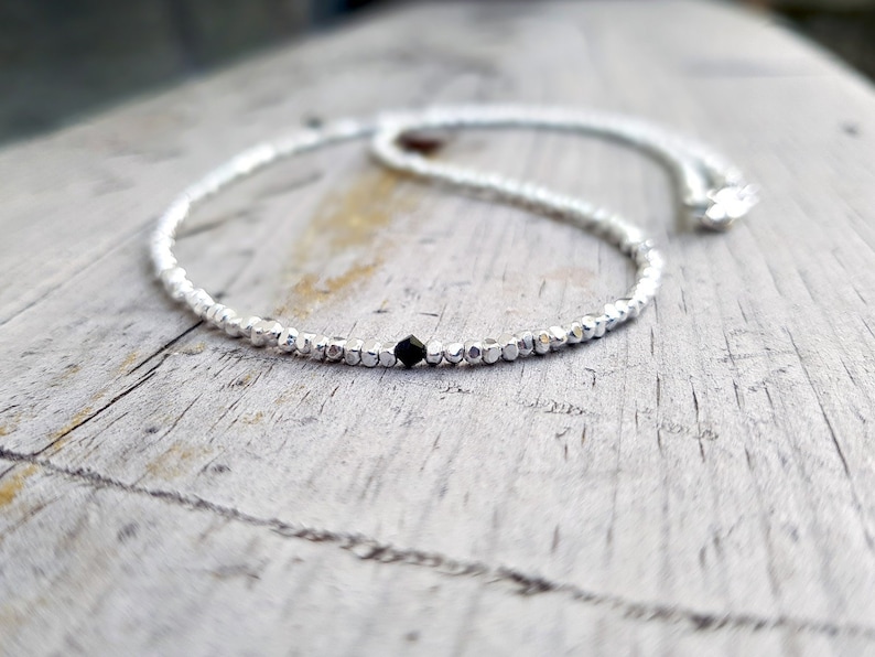 collana elegante e sottile, perfetta per uomo o donna, composta da pepite in argento solido ed al centro un piccolo cristallo in tre colori a scelta tra nero, verde smeraldo e blu zaffiro.