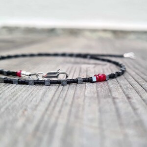 collana sottile ed elegante da uomo composta da pietre di ematite a forma di cubo  alternate con perline giapponesi di colore nero al centro tre pietre di rubino naturale