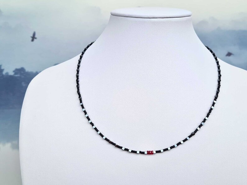 collana sottile ed elegante da uomo composta da pietre di ematite a forma di cubo  alternate con perline giapponesi di colore nero al centro tre pietre di rubino naturale