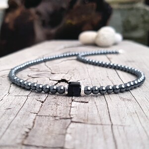 May include: A black hematite beaded necklace with a square black onyx pendant.