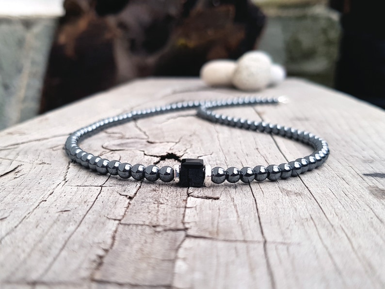 May include: A black hematite beaded necklace with a square black onyx pendant.