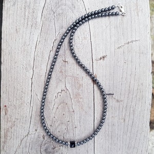May include: A black hematite beaded necklace with a square-shaped hematite pendant.