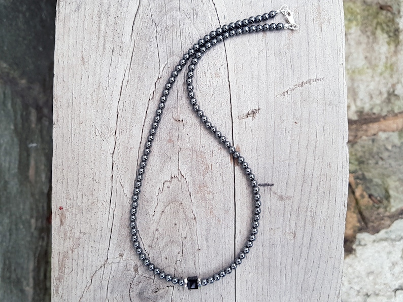 May include: A black hematite beaded necklace with a square-shaped hematite pendant.