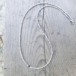 collana elegante e sottile, perfetta per uomo o donna, composta da pepite in argento solido ed al centro un piccolo cristallo in tre colori a scelta tra nero, verde smeraldo e blu zaffiro.