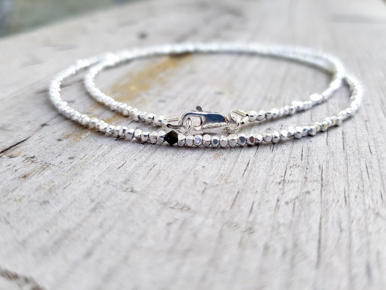 collana elegante e sottile, perfetta per uomo o donna, composta da pepite in argento solido ed al centro un piccolo cristallo in tre colori a scelta tra nero, verde smeraldo e blu zaffiro.