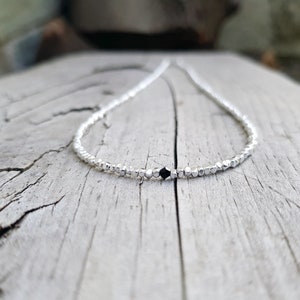 collana elegante e sottile, perfetta per uomo o donna, composta da pepite in argento solido ed al centro un piccolo cristallo in tre colori a scelta tra nero, verde smeraldo e blu zaffiro.