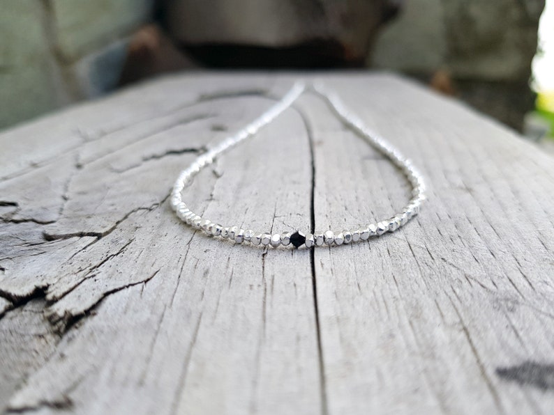 collana elegante e sottile, perfetta per uomo o donna, composta da pepite in argento solido ed al centro un piccolo cristallo in tre colori a scelta tra nero, verde smeraldo e blu zaffiro.