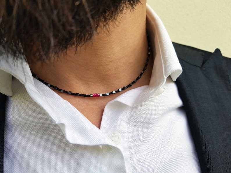 collana sottile ed elegante da uomo composta da pietre di ematite a forma di cubo  alternate con perline giapponesi di colore nero al centro tre pietre di rubino naturale