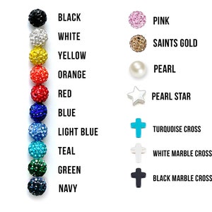 May include: A chart displaying various bead and charm colours. The colours include black, white, yellow, orange, red, blue, light blue, teal, green, and navy. The charms include a pink bead, a gold bead, a pearl, a pearl star, a turquoise cross, a white marble cross, and a black marble cross.